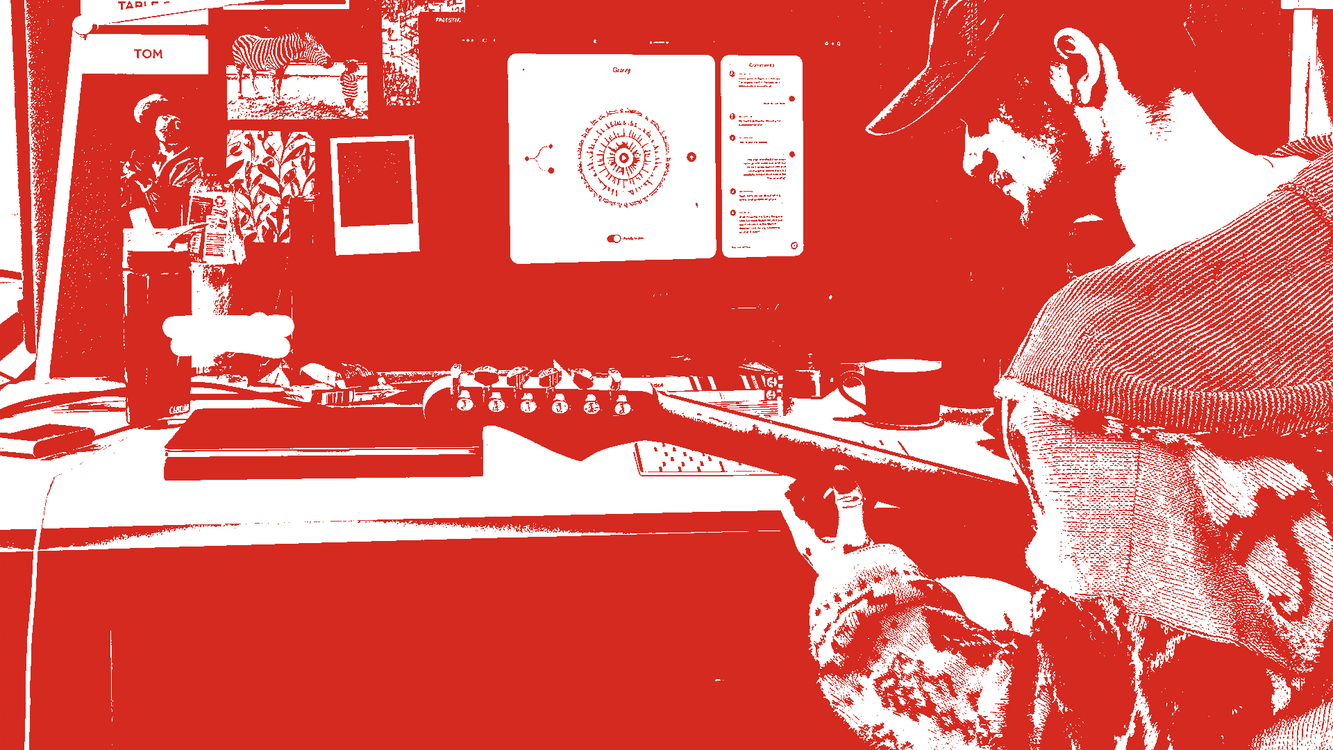 A person using the BeeSide platform at their desk, with a guitar in their hands.